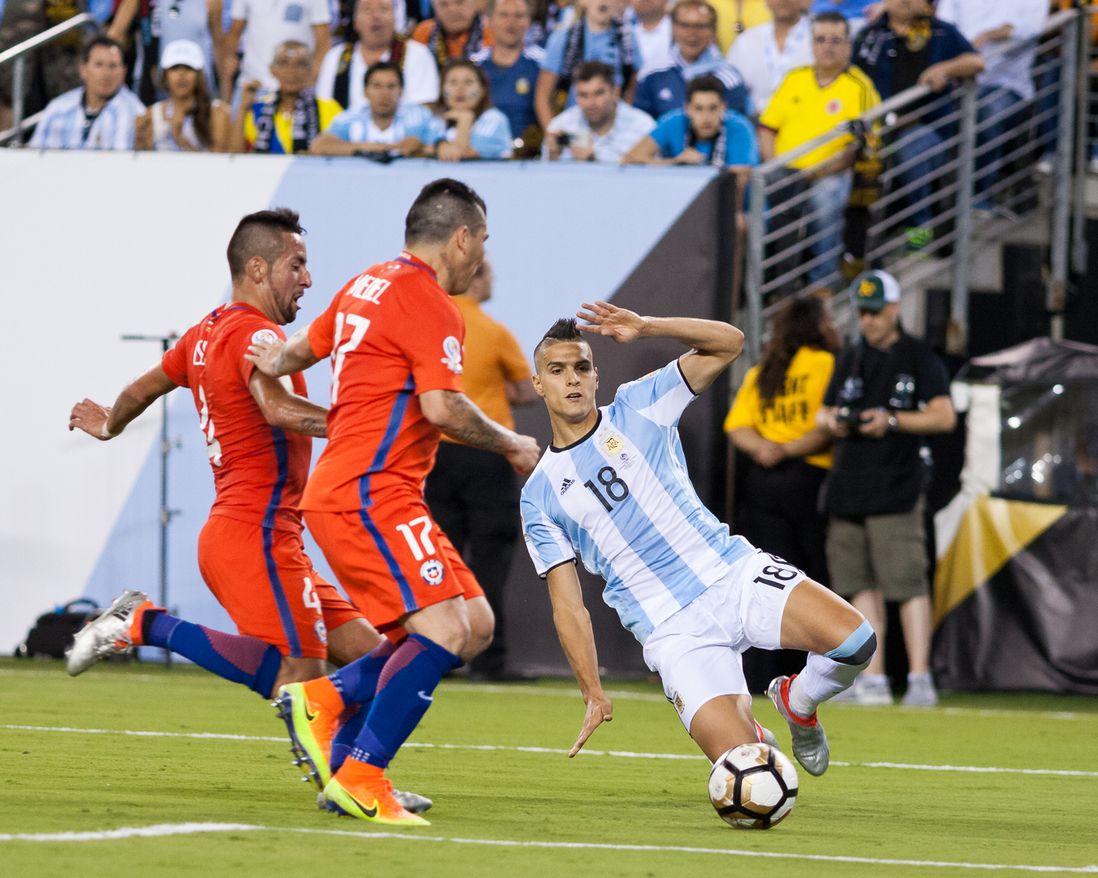 Argentina's Erik Lamela (18) vies with Chile's Gary Medel (17) and Mauricio Isla (4).